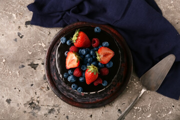 Sweet chocolate cake with fresh berries on grey background