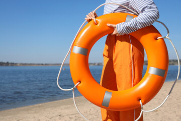 Female sailor with lifebuoy ring on sea beach