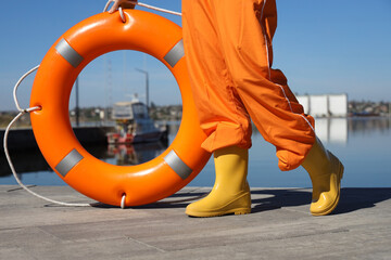 Female sailor with life ring on pier near river