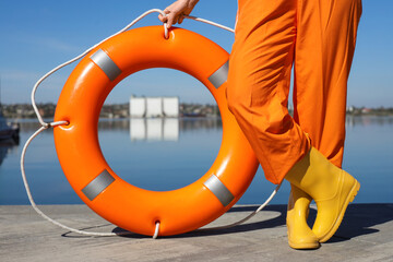 Female sailor with life ring on pier near river