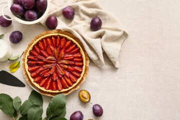 Plate with tasty plum pie, spatula and fresh fruits on table