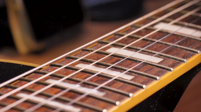Close up shot the hand using microfiber fabric to clean the fret board of electric guitar