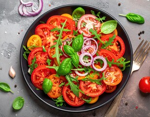 Overhead shot of a colorful tomato salad with onions and basil