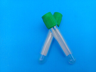 Colorful empty blood test tubes on blue background, symbolizing medical equipment, laboratory tools, healthcare, diagnostics, and scientific research.