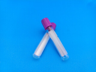 Colorful empty blood test tubes on blue background, symbolizing medical equipment, laboratory...