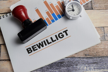 Concept of bewilligt in German it means approved write on book with keywords isolated on Wooden Table.