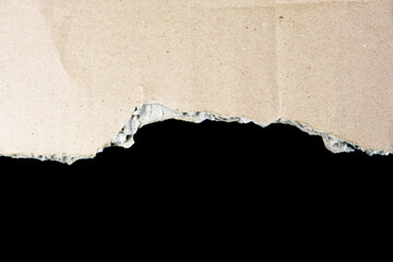 Ripped cardboard paper scraps. Piece of torn cardboard isolated on black background. damaged carton top view.  recycled cardboard.