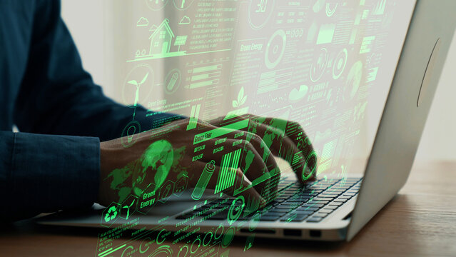 A person typing on a laptop with green energy graphics overlay, illustrating the intersection of technology, sustainability, and modern workspace solutions for future innovations. Cipher - Powered by Adobe