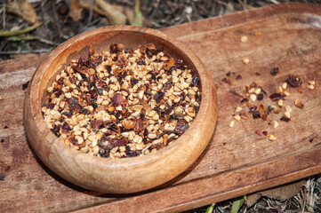 Dried rosehip in wooden bowl on wooden background. No people.