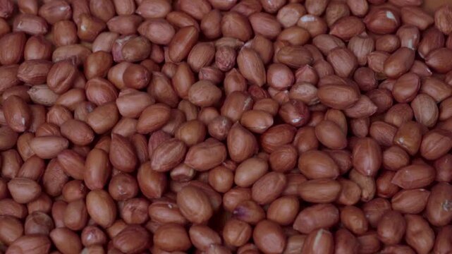 Close-up Macro Shot of Brown Peeled Peanuts Falling and Piling Up