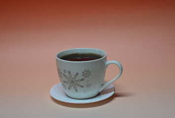 Weisse Tasse schwarzer Tee mit Schneeflocken