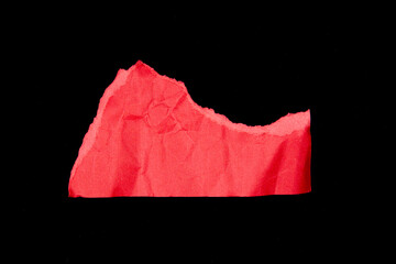 Crumpled red paper pieces isolated on black background