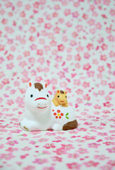 可愛い馬の置物と花柄の背景の年賀状素材