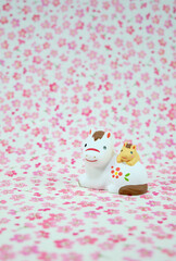 可愛い馬の置物と花柄の背景の年賀状素材