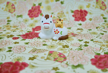 可愛い馬の置物と和柄の背景の年賀状素材