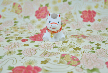 可愛い馬の置物と和柄の背景の年賀状素材