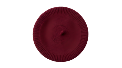 Deep red woolen circular headwear rests against a solid black background viewed from directly above.