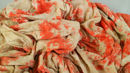 Crumpled beige fabric with red tie dye texture pattern