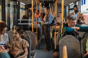 Diverse people commuting on a public transportation bus © PintoArt