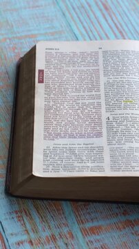 Close up view of the book of John chapter 3 verse 16 of the new testament, Holy Bible. Printed form, the New Revised Standard version. High angle, vertical video
