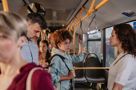 Diverse passengers commuting on crowded urban public bus