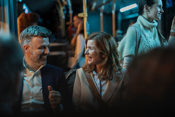 Couple laughing traveling on busy public transport at night
