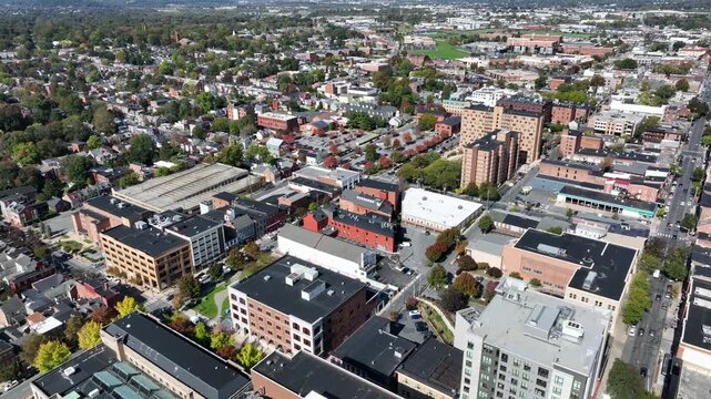 Drone flight over Lancaster Downtown with offices and apartment towers during sunny day. Colored trees in fall season. Historic old town of american town in Pennsylvania, USA.