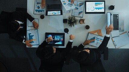 Top down aerial view of smart manager pointing at financial graph on whiteboard while diverse...