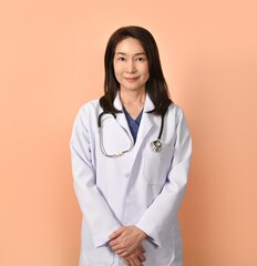 Portrait of asian female doctor in medical uniform with stethoscope on peach color background.
