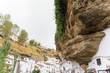 White houses constructed into massive rock overhangs, creating a unique and characteristic village in setenil de las bodegas ,andalusia, spain
