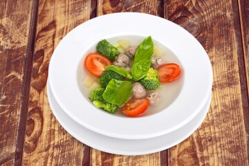 Spring fresh vegetable soup in bowl on the desk