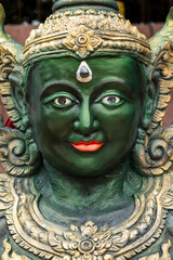 Close-up of vibrant green Ganesha statue from Mahadevalai Temple, Bangkok. Adorned with golden crown, third eye, and intricate traditional jewelry.