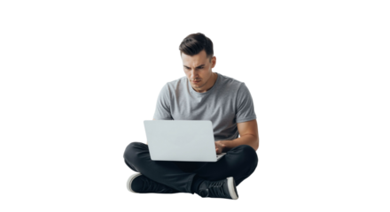 Man working on laptop in cross-legged position with focused expression