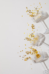 Champagne glass with party serpentine streamers and golden confetti stars top view. New Year,...