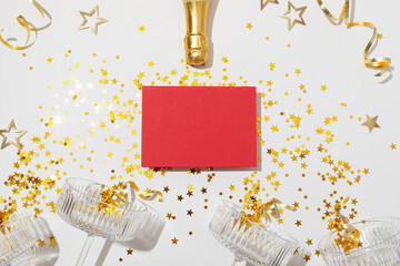 Party fashion background with champagne glasses, paper card, bottle and golden confetti stars. New...