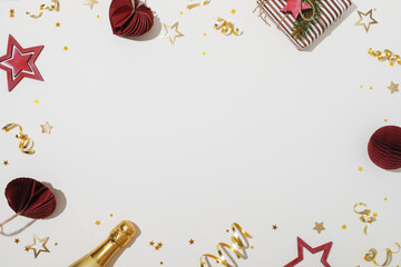 Christmas frame background with gift box, champagne bottle, red paper balls and gold stars on white...