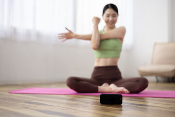 Smartphone-Focused Shot of Japanese Woman Taking Online Yoga Class at Home
