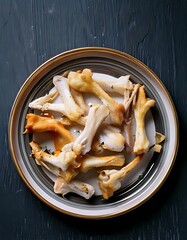 Plate of Chanterelle Mushrooms on Dark Wooden Surface.