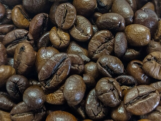 Close-up of roasted coffee beans showing various shades of brown and textures for a rich coffee experience