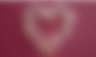 Close up of delicate hands forming a heart shape against a soft pink background