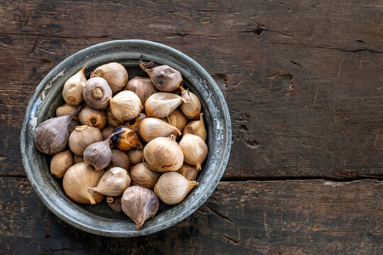 Black garlic, aged garlic in the wood bowl. 