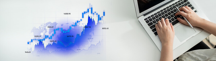 A person is typing on a laptop with a focus on a financial graph that represents growth and market trends, showcasing a blend of technology and analytical insight in a professional setting. Scalp