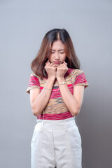 Asian Woman Showing Worried Expression with Closed Eyes