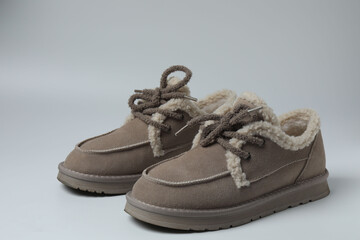 A pair of new women's short boots with medium-high heels on a gray background, studio shot.
