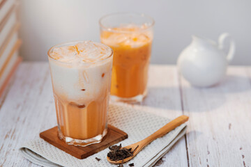 Thai tea with milk in a glass jar placed on a wooden table