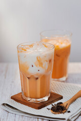 Thai tea with milk in a glass jar placed on a wooden table