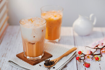 Thai tea with milk in a glass jar placed on a wooden table