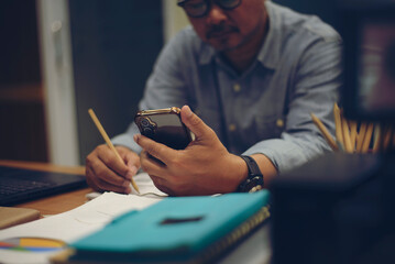 Season to pay Tax and Budget planning concept. Businessman calculating annual tax and using mobile...