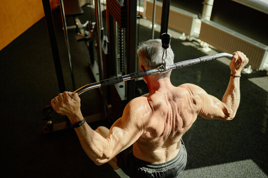 Senior Man Exercising on Lat Pulldown Machine in Fitness Center