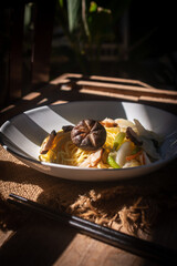 A rustic vegetarian noodle dish served with shiitake mushrooms, set amidst warm natural light, perfect for promoting vegan, Asian, food menus and healthy . with its beautiful rustic presentation.
